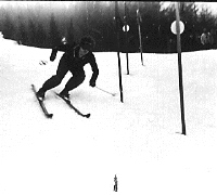 Slalom Planiškega tedna v Kranjski Gori. Smučar se je moral kar izogibati debelim kolcem vratc.