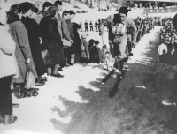 Smučarski tekač leta 1949 od Rateč proti Planici in naprej proti Tamarju v špalirju gledalcev (Planiški teden).