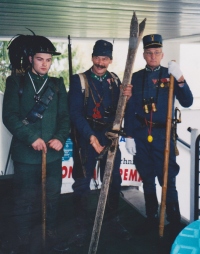 Skupina 13-13 (Dreizeh-Dreizehn) iz Tolmina je na EMAUS-u nastopila oblečena v avstrijske in italijanske vojake iz prve svetovne vojne. 13-13 je višinska kota brega, ki se je vkopala na višini 1313 m nadmorske višine in čakala sovražnikove vojake.