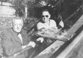 Stanko Bloudek (na levi) je naredil načrte in zgradil leta 1956 suho skakalnico na Ljubljanici v Ljubljani. Skakalec je stopil na leseni kotalki na vrhu zaletišča in se spustil v globokem počepu po dveh žlebovih, po katerih je tekla voda …